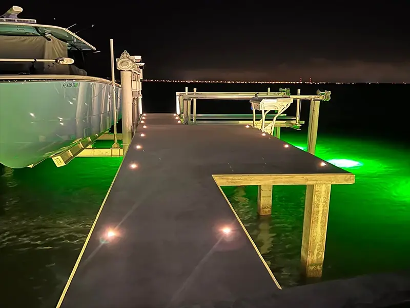 Boat dock at night with step lights and green underwater lights